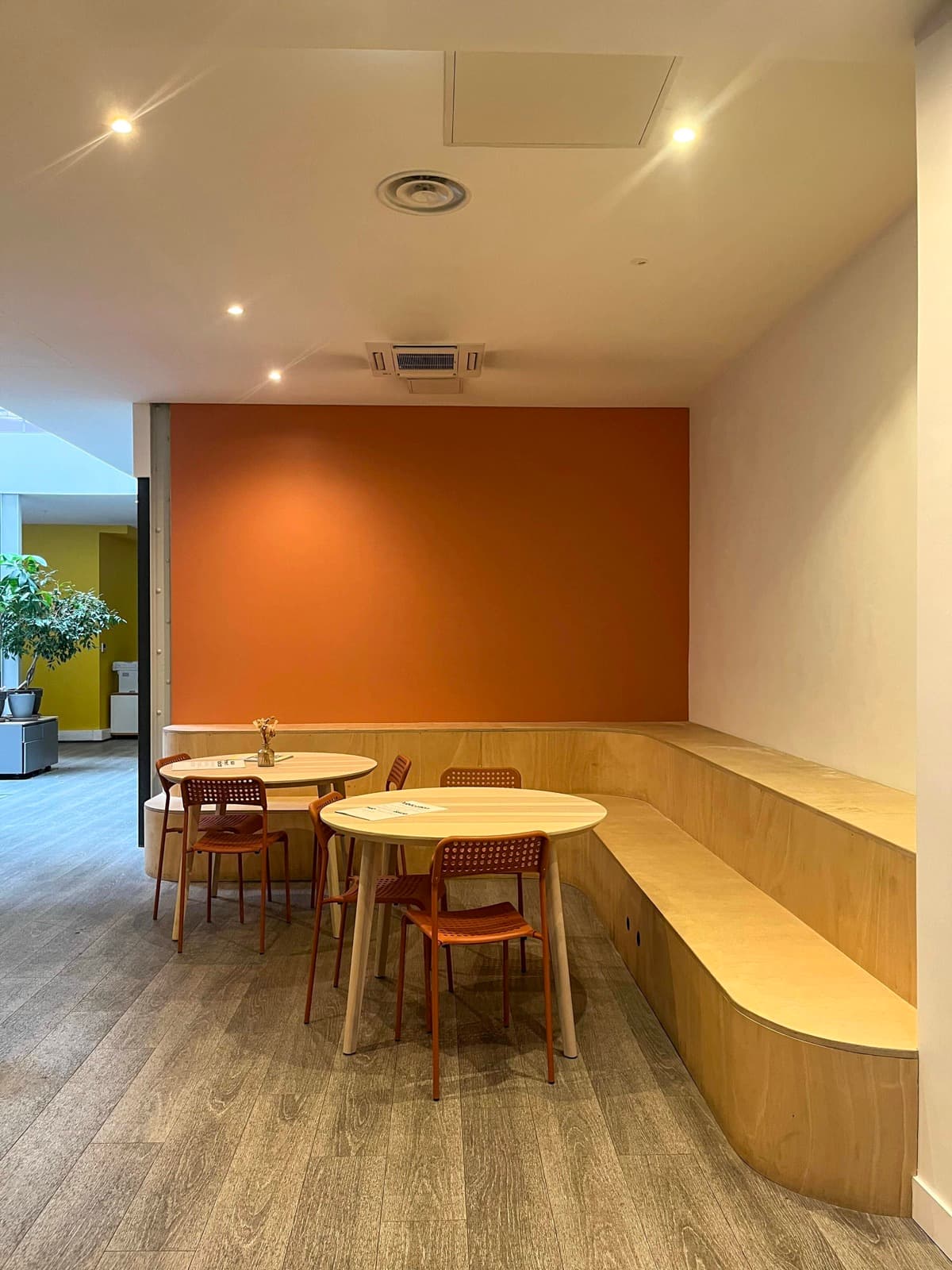 Coin lounge avec tables rondes et banc en bois clair